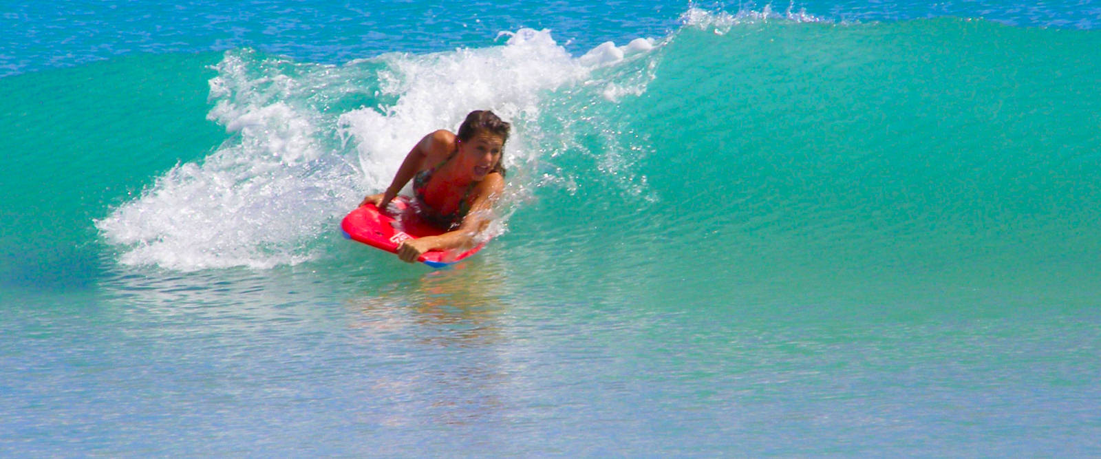 Happy kids boogie boarding on a beach in Pembrokeshire